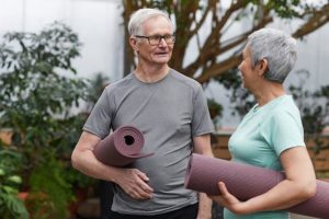 trust instead of a will, image of senior couple holding yoga mats chatting
